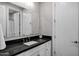 Modern bathroom with black countertop, white cabinetry, and sleek fixtures at 17937 E Colt Ct, Queen Creek, AZ 85142