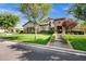 Beautiful exterior of home with lush green lawn, mature trees, and a charming brick entryway at 17937 E Colt Ct, Queen Creek, AZ 85142