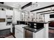 Spacious kitchen featuring black countertops, a white farmhouse sink, and stainless steel appliances at 17937 E Colt Ct, Queen Creek, AZ 85142
