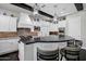Bright kitchen features white cabinetry, black countertops, decorative lighting, and stainless steel appliances at 17937 E Colt Ct, Queen Creek, AZ 85142