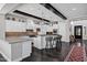 Modern kitchen with white cabinets, wood beam accents, stainless steel appliances, and a spacious island at 17937 E Colt Ct, Queen Creek, AZ 85142