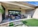 Covered outdoor patio with wicker furniture, ceiling fan, built-in bar and turf grass at 17937 E Colt Ct, Queen Creek, AZ 85142