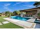 Backyard swimming pool has a swim-up bar, full outdoor kitchen, and well manicured landscaping at 17937 E Colt Ct, Queen Creek, AZ 85142