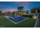Beautiful backyard oasis with pool, spa, covered patio, lush landscaping, and warm fire features at 17937 E Colt Ct, Queen Creek, AZ 85142