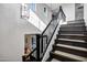 Elegant staircase with dark wood stairs, white risers, and a decorative chandelier at 17937 E Colt Ct, Queen Creek, AZ 85142
