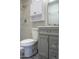 Bathroom features gray vanity, gray tile, shower with shower head, and white toilet at 19511 N 76Th Ave, Glendale, AZ 85308