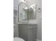Bathroom features gray vanity, gray mirror, and white toilet in a modern style at 19511 N 76Th Ave, Glendale, AZ 85308