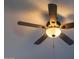 Classic ceiling fan with warm lighting, creating a cozy and inviting ambiance in the living space at 19511 N 76Th Ave, Glendale, AZ 85308