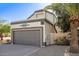Charming exterior with a two-car garage, mature landscaping, and decorative accents at 19511 N 76Th Ave, Glendale, AZ 85308