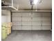 Spacious two car garage with neutral colored doors, concrete floors, and multiple trash cans at 19511 N 76Th Ave, Glendale, AZ 85308