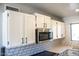 Bright kitchen with white cabinets, subway tile backsplash, stainless steel appliances, and modern countertops at 19511 N 76Th Ave, Glendale, AZ 85308