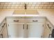 Close-up of the kitchen sink featuring a double basin, modern faucet, and elegant countertops with white cabinets at 19511 N 76Th Ave, Glendale, AZ 85308