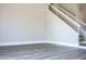 Bright living room with gray wood-look flooring, white baseboards, and a staircase to the upper level at 19511 N 76Th Ave, Glendale, AZ 85308