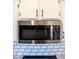 Stainless steel microwave and subway tile backsplash sit above speckled countertops in this updated kitchen at 19511 N 76Th Ave, Glendale, AZ 85308