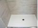 The walk-in shower features sleek gray stone walls and a modern shower drain, combining style with easy maintenance at 19511 N 76Th Ave, Glendale, AZ 85308