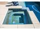 Inviting in-ground spa with surrounding stone trim and blue tile accents for relaxation and enjoyment at 19511 N 76Th Ave, Glendale, AZ 85308