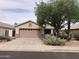 Tan single-story home featuring a two-car garage and desert landscaping at 21214 N 80Th Ln, Peoria, AZ 85382