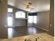 Open-concept living room with wood floors, ceiling fan, and plenty of natural light at 21214 N 80Th Ln, Peoria, AZ 85382