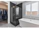 Modern bathroom boasting a glass-enclosed shower, soaking tub, and convenient access to a walk-in closet at 21930 N 29Th St, Phoenix, AZ 85050