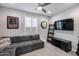 Bonus room includes a large sectional couch, TV, shuttered window, and ceiling fan at 21930 N 29Th St, Phoenix, AZ 85050