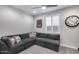 A cozy bonus room features gray walls, a ceiling fan, a large couch, and natural light at 21930 N 29Th St, Phoenix, AZ 85050