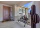 Inviting covered front porch with a metal bench, desert landscaping, and a stylish front door at 21930 N 29Th St, Phoenix, AZ 85050
