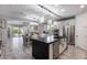 Open-concept kitchen with stainless steel appliances, white cabinets, a black island, and modern lighting at 21930 N 29Th St, Phoenix, AZ 85050