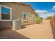 View of back of the house with AC unit and fenced backyard with a pine tree at 2464 N Morrison Ave, Casa Grande, AZ 85122
