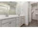 Bathroom with dual sinks, white cabinets, and large mirror with plenty of light in a modern home at 2464 N Morrison Ave, Casa Grande, AZ 85122
