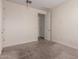 A bright bedroom with neutral walls and carpet; door leading to another room at 2464 N Morrison Ave, Casa Grande, AZ 85122