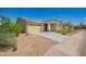 Single-story home with desert landscaping, spacious driveway leading to a two-car garage, and covered entryway at 2464 N Morrison Ave, Casa Grande, AZ 85122