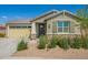 Single-story home boasts stone accents, desert landscaping, and a covered front entry under a clear blue sky at 2464 N Morrison Ave, Casa Grande, AZ 85122