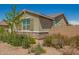 Low water landscaping complements this single-story home featuring a neutral stucco exterior with stone accents and a gray roof at 2464 N Morrison Ave, Casa Grande, AZ 85122