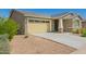 Attached two-car garage featuring paneled windows, desert landscaping, and a wide driveway at 2464 N Morrison Ave, Casa Grande, AZ 85122