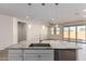 Kitchen island with granite countertop and stainless sink overlooking an open-concept living area and sliding glass doors at 2464 N Morrison Ave, Casa Grande, AZ 85122