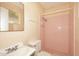 Bathroom featuring a pink tiled shower with curtain and a cream-colored vanity and toilet at 2614 W Greenway Rd, Tempe, AZ 85282