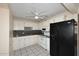 Efficient kitchen featuring white cabinets, black appliances, and tiled flooring at 2614 W Greenway Rd, Tempe, AZ 85282