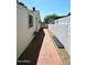 Brick pathway leads through the side yard between the home and white block wall at 2614 W Greenway Rd, Tempe, AZ 85282