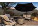 Relaxing backyard setting with a stone fire pit, comfortable seating, and a large shade umbrella at 263 S Del Rancho --, Mesa, AZ 85208