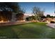 Beautifully landscaped backyard with artificial grass, brick accents, and soft lighting, ideal for evening enjoyment at 263 S Del Rancho --, Mesa, AZ 85208