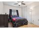 Comfortable bedroom with modern black and red bedding, dark curtains, and a ceiling fan at 263 S Del Rancho --, Mesa, AZ 85208