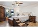Cozy main bedroom with plush carpeting, decorative side tables, dog steps, and a ceiling fan at 263 S Del Rancho --, Mesa, AZ 85208