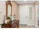 Inviting entryway with a decorative mirror, wooden table, neutral paint, and a white front door at 2731 E Cherry Hill Dr, Gilbert, AZ 85298