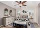 Serene main bedroom with a ceiling fan, a wooden dresser, a bench, and plantation shutters at 2731 E Cherry Hill Dr, Gilbert, AZ 85298