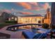 Inviting backyard pool area featuring a covered patio and a tranquil outdoor living space at twilight at 29227 N 44Th St, Cave Creek, AZ 85331