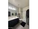 Full bathroom with double sink vanity, shower-tub combo with black curtain, and black bath mat at 3012 N 310Th Ln, Buckeye, AZ 85396
