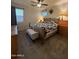 Cozy bedroom with wooden furniture set including bed, dressers, bench, and ceiling fan at 3012 N 310Th Ln, Buckeye, AZ 85396