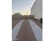 A view of the side yard with custom wooden gate and concrete pathway to the back yard at 3012 N 310Th Ln, Buckeye, AZ 85396