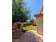 Backyard featuring artificial grass surrounded by lush, mature landscaping at 3085 E Patrick St, Gilbert, AZ 85295