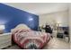 Comfortable bedroom with a patchwork quilt bedspread, a blue accent wall, and arched window desk area at 3124 W Taro Ln, Phoenix, AZ 85027